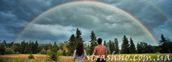 счастливая пара под радугой на опушке леса