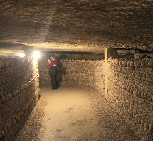 туристка в парижских катакомбах