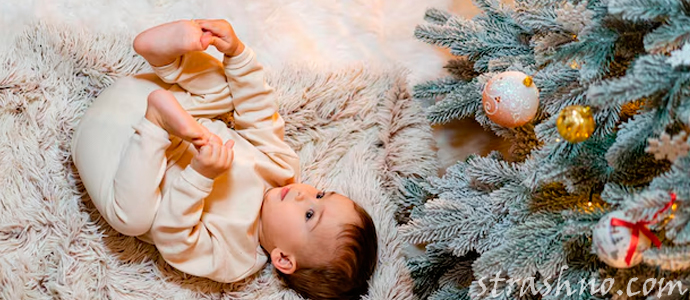 маленький ребенок возле новогодней елки