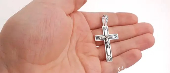серебряный кресик на ладони